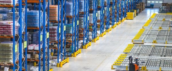 Distribution warehouse building interior and large storage area with goods on the shelf.